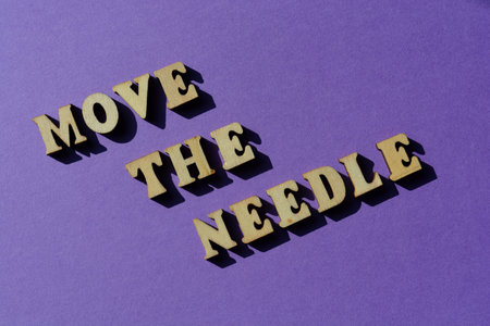 Move The Needle, words in wooden alphabet letters isolated on purple backgroundの写真素材