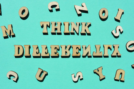 Think Differently, words in wooden alphabet letters isolated on backgroundの写真素材