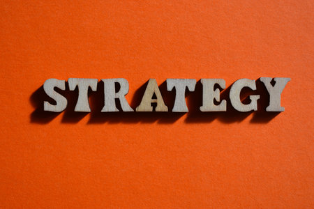 Strategy, word in wooden alphabet letters isolated on orange backgroundの写真素材