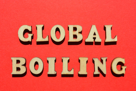 Global Boiling, words in wooden alphabet letters isolated on red backgroundの写真素材