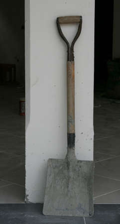 Old shovel against wallの写真素材