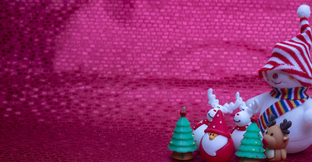Christmas decorations, little dolls and big snow doll on red background with copy spaceの写真素材