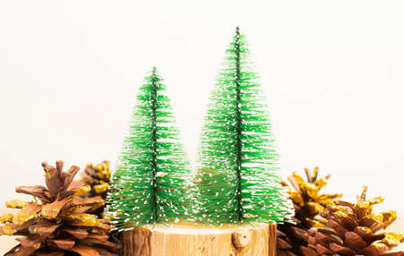 Green Christmas trees on the log and with pine cones, white background and copy space.の写真素材
