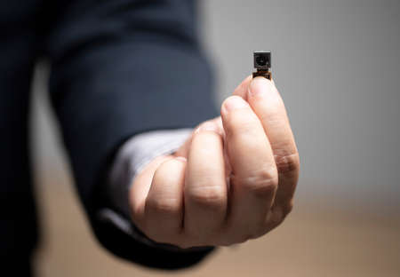 Legal security, pinhole camera, privacy of Personal Information , businessman holding pinhole camera in hand.の写真素材