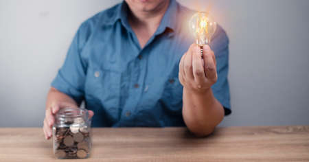 man putting money into jar bank Save for future home purchases. money saving planning, business, finance, payment guidelines, financial concept.の写真素材