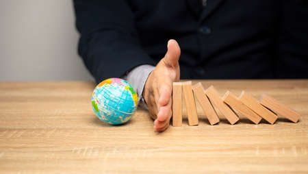 concept of saving the world cleaning, campaign Natural environment, global warming, men's hands blocking wooden blocks prevent being destroyed.の写真素材