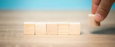 Man hand holding a wooden block lay on table, marketing ideas, business concept, economic growth.の写真素材