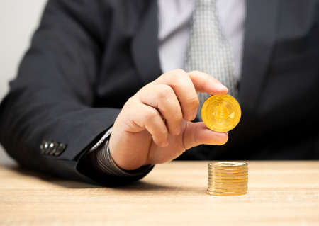 Businessman holding gold coins in hand, future financial investment money planning theory