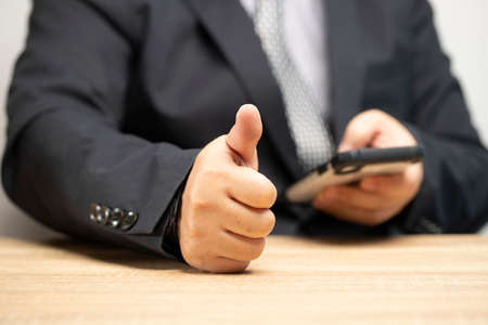 Business people rate service satisfaction. Thumbs up for the utmost satisfaction. mobile rating satisfaction surveyの写真素材