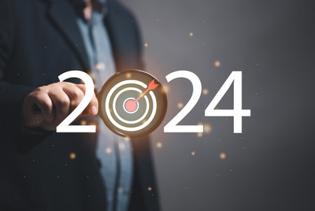 Marketer holding a magnifying glass to focus on marketing goals for 2024, setting marketing goals for next year. organization growth Setting guidelines for doing business. Marketing strategy and goal.の写真素材