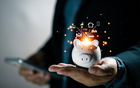 Concepts about saving money. A man saves money in a piggy bank by making online transactions using his mobile phone. Depositing money, saving money, investing, reducing future risk.の写真素材