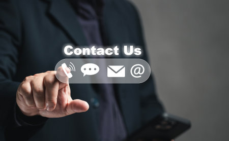 contact us or Customer support hotline service. Businessmen use mobile phones to find company contact information from the internet, addresses, online mail, chat inquiries, telephone numbers.の写真素材