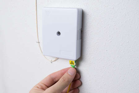 Hand placing or plugging in an internet cable or fiber optic