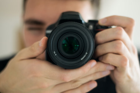 close-up of a boy taking a picture with a professional camera. Concept of photography, hobby, business.の写真素材