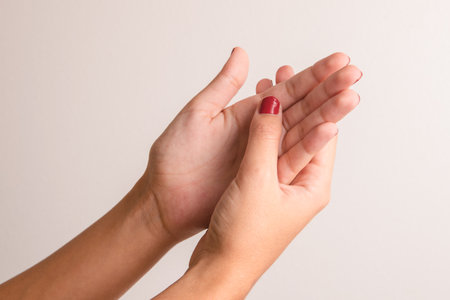 woman stroking her hands or putting on cream to hydrate her skin. Wellness and beauty conceptの写真素材