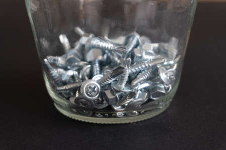 glass jar with screws inside. Concept organize material
