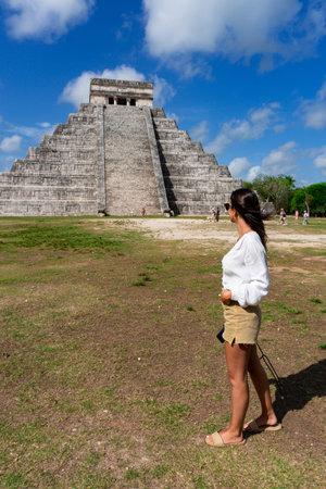 Tourist girl in front of the background of the Kukulcan pyramid in the Mexican city of Chichen Itza. Travel concept. Mayan pyramids in Yucatan, Mexicoの写真素材