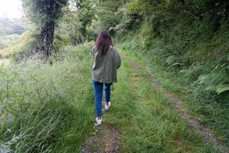 Girl walking on a path in the green forest in Galicia. Adventure and nature conceptの写真素材