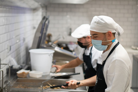 Chefs making food and cooking in a business. Work and kitchen concept.の写真素材