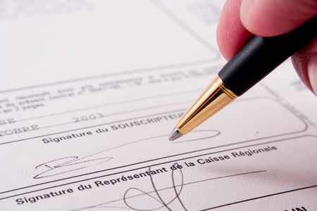 Close up of a hand signing a document. Please note that the signature is fictitious.