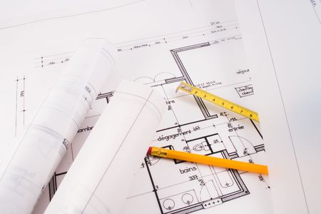 Plans of a  designed by an architect with a yellow pencil and an instrument of measurementの写真素材