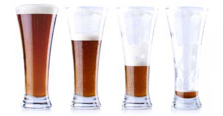 Four glasses of beer in various stages, from full to emptyの写真素材