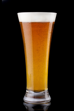 Glass of fresh beer on a black backgroundの写真素材