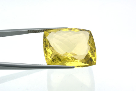 Close-up of lemon quartz stone fastened with jewelry pliers on neutral backgroundの写真素材