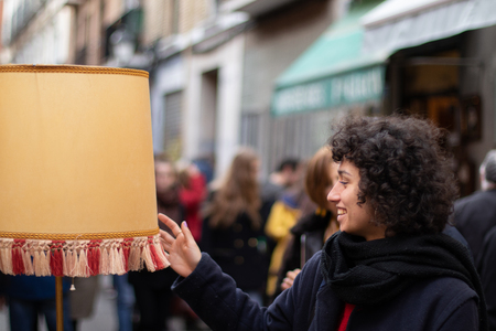 Young girl observing a lamp in an antique marketの写真素材