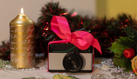 Retro photo camera Christmas gift with decoration and candlesの写真素材