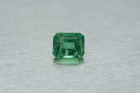 Gemstone carved of emerald on gray metallic backgroundの写真素材