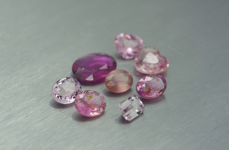 Group of pink and purple gemstones on metal surfaceの写真素材