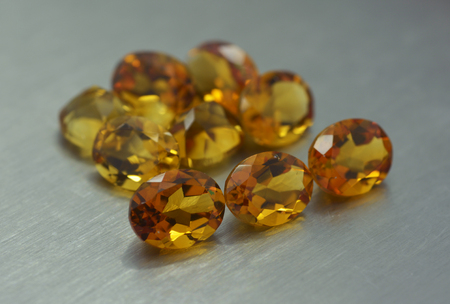 Group of ocher colored gemstones on metal surfaceの写真素材