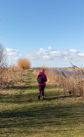 Person hiking with a backpack in a beautiful natural landscape on a sunny dayの写真素材