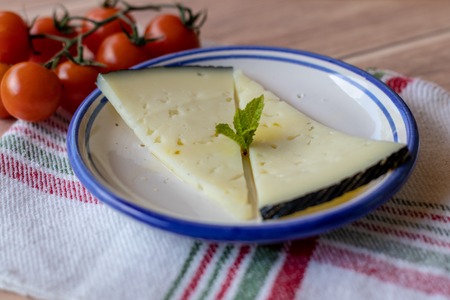 Tasty cheese in a ceramic dish with extra virgin olive oil, cherry tomatoes and a mint leaf. Mediterranean rustic appetizerの写真素材