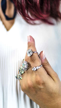 Elegant woman's hand full of rings of different colors and shapes. Various precious stones sapphire, ruby, diamond ...の写真素材