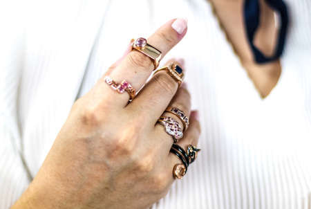 Elegant woman's hand full of rings of different colors and shapes. Various precious stones sapphire, ruby, diamond ...の写真素材