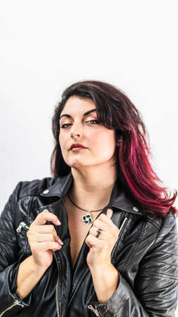 Sexy chubby woman with dyed hair in a leather jacket and with a pendantの写真素材