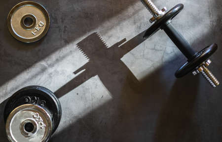 Dumbbells and various weight plates on a concrete surface. Background with empty space.の写真素材