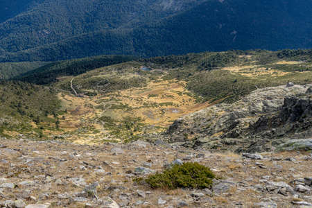 Top view of a dry glacial lagoon during autumn between the mountains. Large lagoon of PeÃ±alara, Sierra de Madridの写真素材
