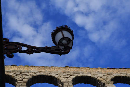 Streetlight with blue sky and clouds with the Segovia's aqueductの写真素材