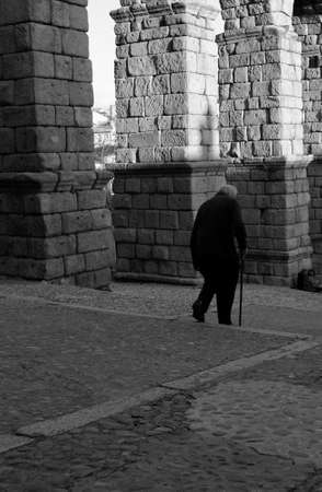 Old man with walking stick near the Segovia's aqueductの写真素材