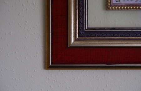 Corner of an red old frame with white wall