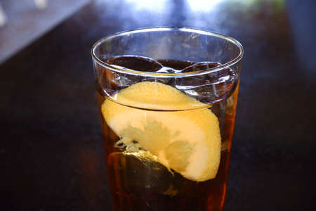 Glass of ice tea and lemon in a bar