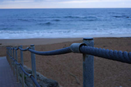 Rail made of rope and steel with sea behindの写真素材