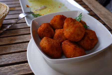 A bowl full of croquettes in a restaurantの写真素材