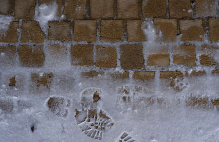 Footprint in the pavement with snow in winterの写真素材