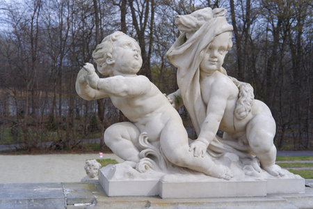 Two marble statues of children outdoors.の写真素材