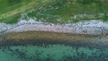Blue sea and beautiful coastline with small waves and algae