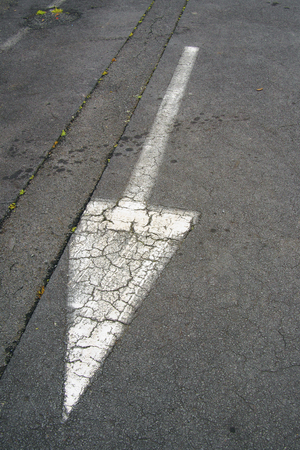 white arrow symbol on black asphalt road